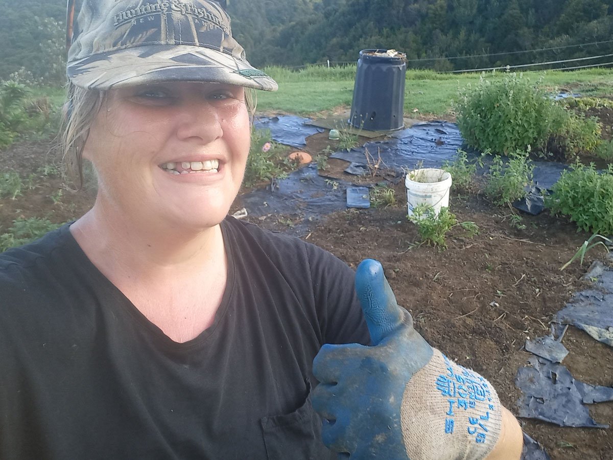 Selfie of Kat doing the thumbs up at the camera after weeding the garden bed.