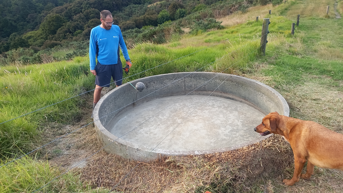 An empty round concrete trough. Richard and Roxy look on.