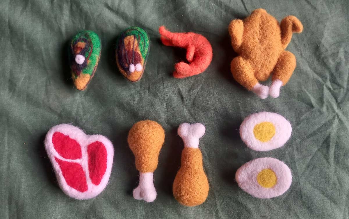 Felted proteins - mussels, a shrimp, a whole ass roast chicken, a steak, two chicken drumsticks, and a hard boiled egg in halves.