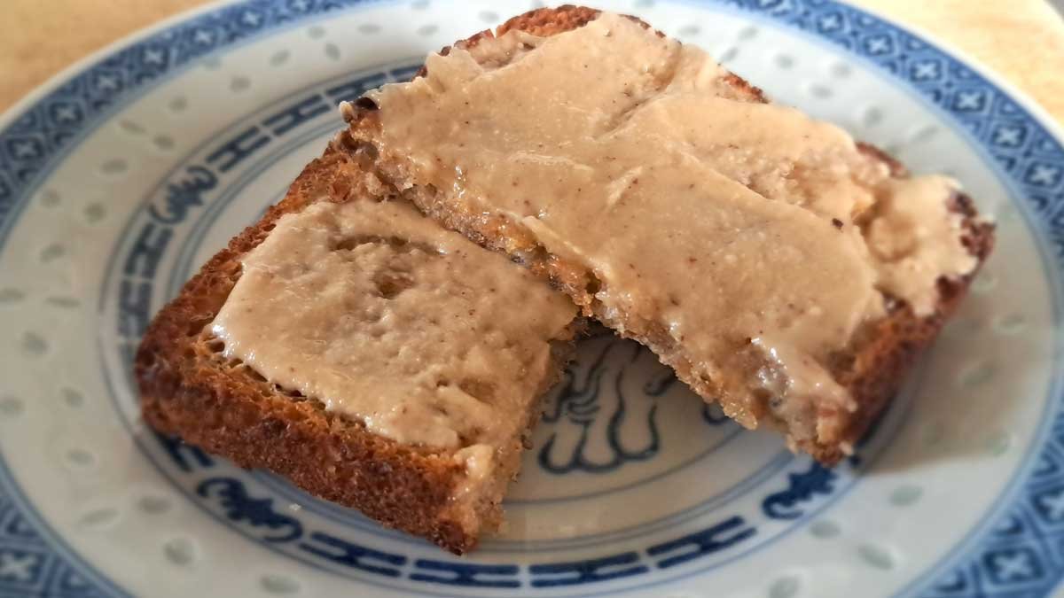 A slice of wholegrain toast smothered in peanut butter.