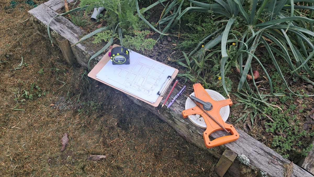 A sketch of the garden and surveying equipment on the edge of a garden bed.