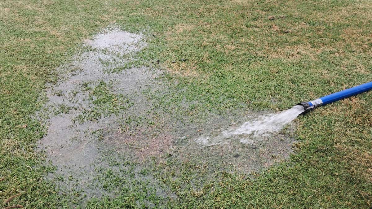 Water being pumped from the tank and puddling on the lawn.
