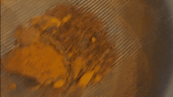 Animated GIF of sifting paprika into a bowl.