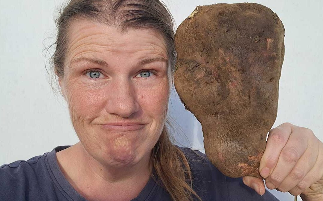 A selfie of Kat and the 1.5 kilogram kumara she harvested in 2026.