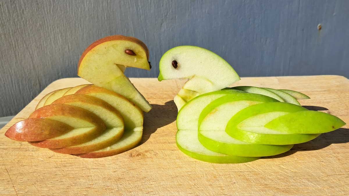 Two swans carved from apples.