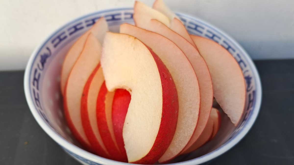 A bowl containing cut segments of piqa boo pear.